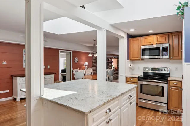 a kitchen with granite countertop a sink a window and cabinets