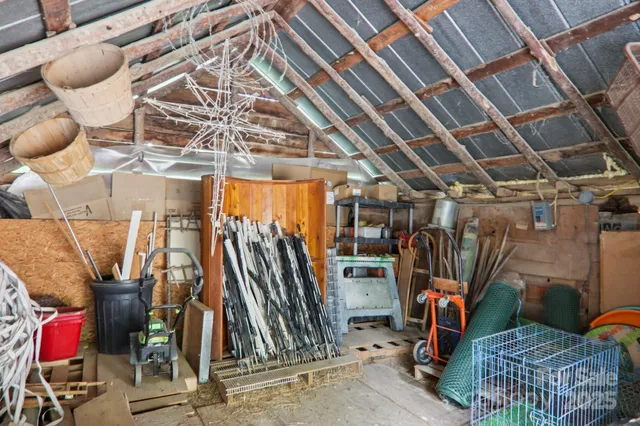 a view of a house with large trees and wooden fence