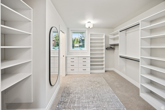 1774 Country Club Drive Logan, UT 84321 - Photo 12 of 28 Spacious walk-in closet featuring extensive built-in shelving, integrated drawer storage, dual hanging rods, and a large oval mirror