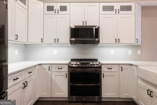 a kitchen with white cabinets and stainless steel appliances