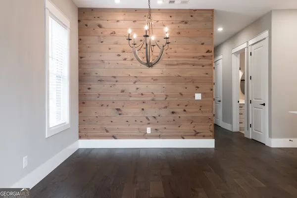 a view of empty room with wooden floor and window