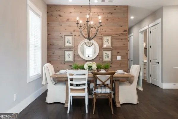 a dining room with furniture a chandelier and wooden floor