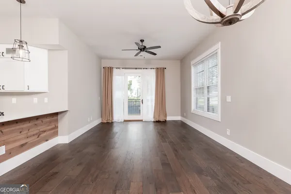 a view of an empty room with a window and wooden floor