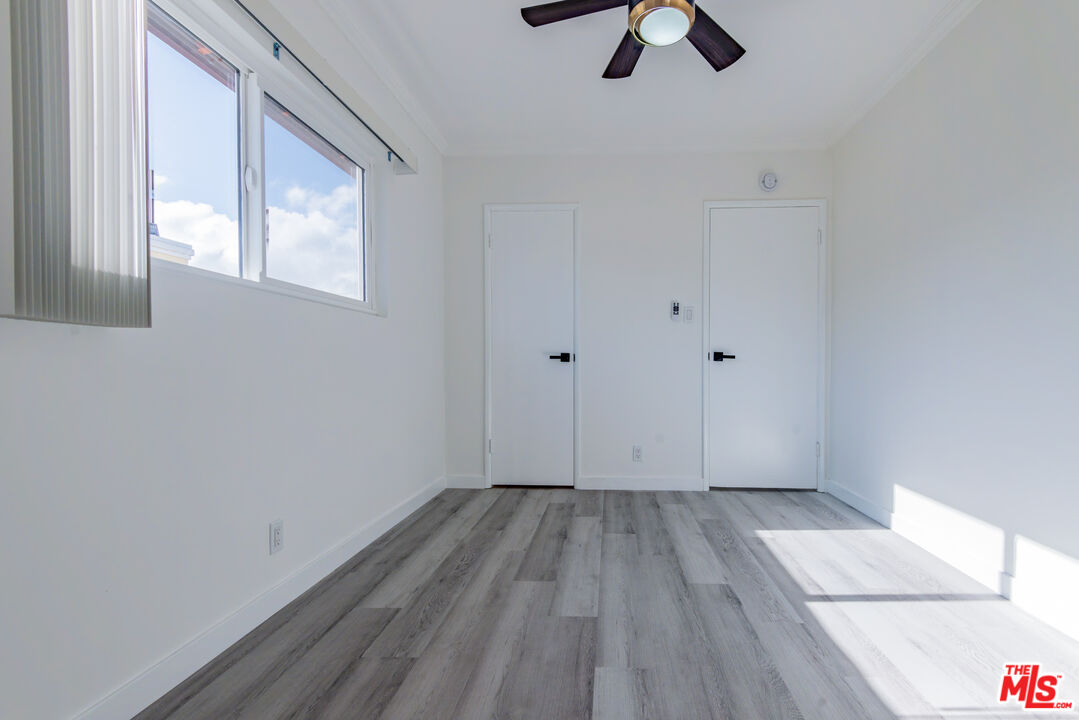 2107 Pullman Lane, Unit D Redondo Beach, CA 90278 - Photo 16 of 32 a view of an empty room with wooden floor and window