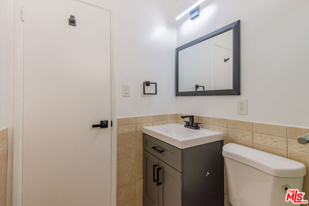 2107 Pullman Lane, Unit D Redondo Beach, CA 90278 - Photo 21 of 32 a bathroom with a toilet sink vanity and mirror