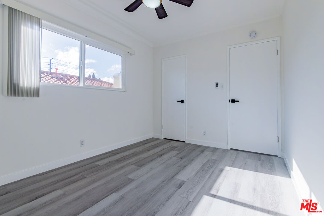 2107 Pullman Lane, Unit D Redondo Beach, CA 90278 - Photo 28 of 32 a view of an empty room with wooden floor and a window