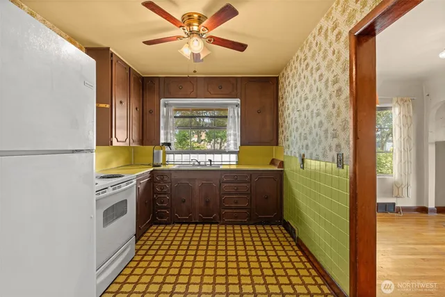 a kitchen with a sink a stove cabinets and wooden floor