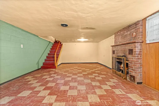 a view of empty room with a fireplace and wooden floor