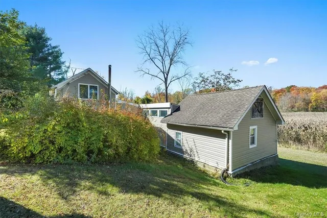 a aerial view of a house in a big yard with large trees