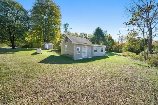 a view of a house with backyard and trees