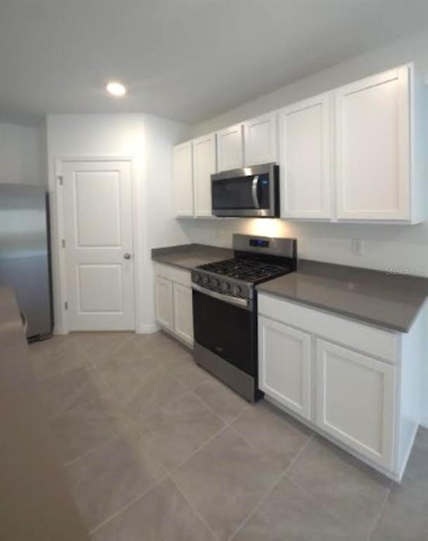 35589 Lockman Way Zephyrhills, FL 33541 - Photo 11 of 54 a kitchen with stainless steel appliances granite countertop a stove a sink and a microwave