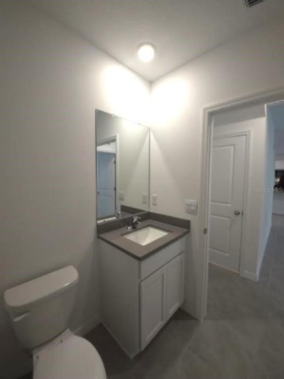 35589 Lockman Way Zephyrhills, FL 33541 - Photo 28 of 54 a bathroom with a granite countertop toilet a sink and a mirror