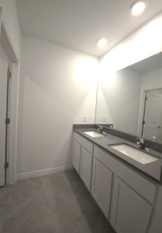 35589 Lockman Way Zephyrhills, FL 33541 - Photo 31 of 54 a bathroom with a double vanity sink and a mirror