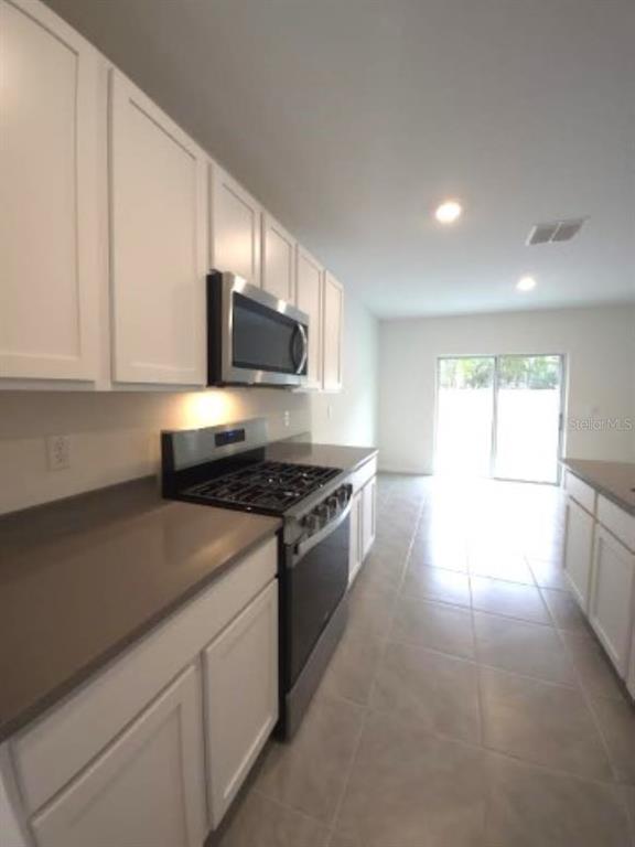 35589 Lockman Way Zephyrhills, FL 33541 - Photo 8 of 54 a kitchen with stainless steel appliances granite countertop a stove a sink and a microwave