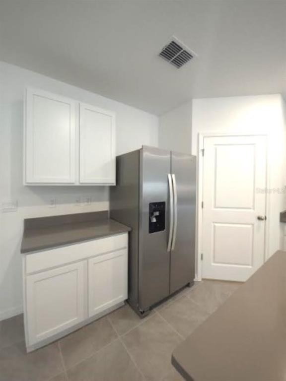 35589 Lockman Way Zephyrhills, FL 33541 - Photo 9 of 54 a close view of a refrigerator in kitchen and white cabinets