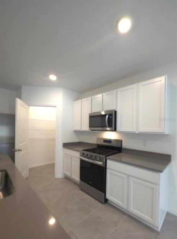 35589 Lockman Way Zephyrhills, FL 33541 - Photo 10 of 54 a kitchen with stainless steel appliances granite countertop a stove a sink and a refrigerator