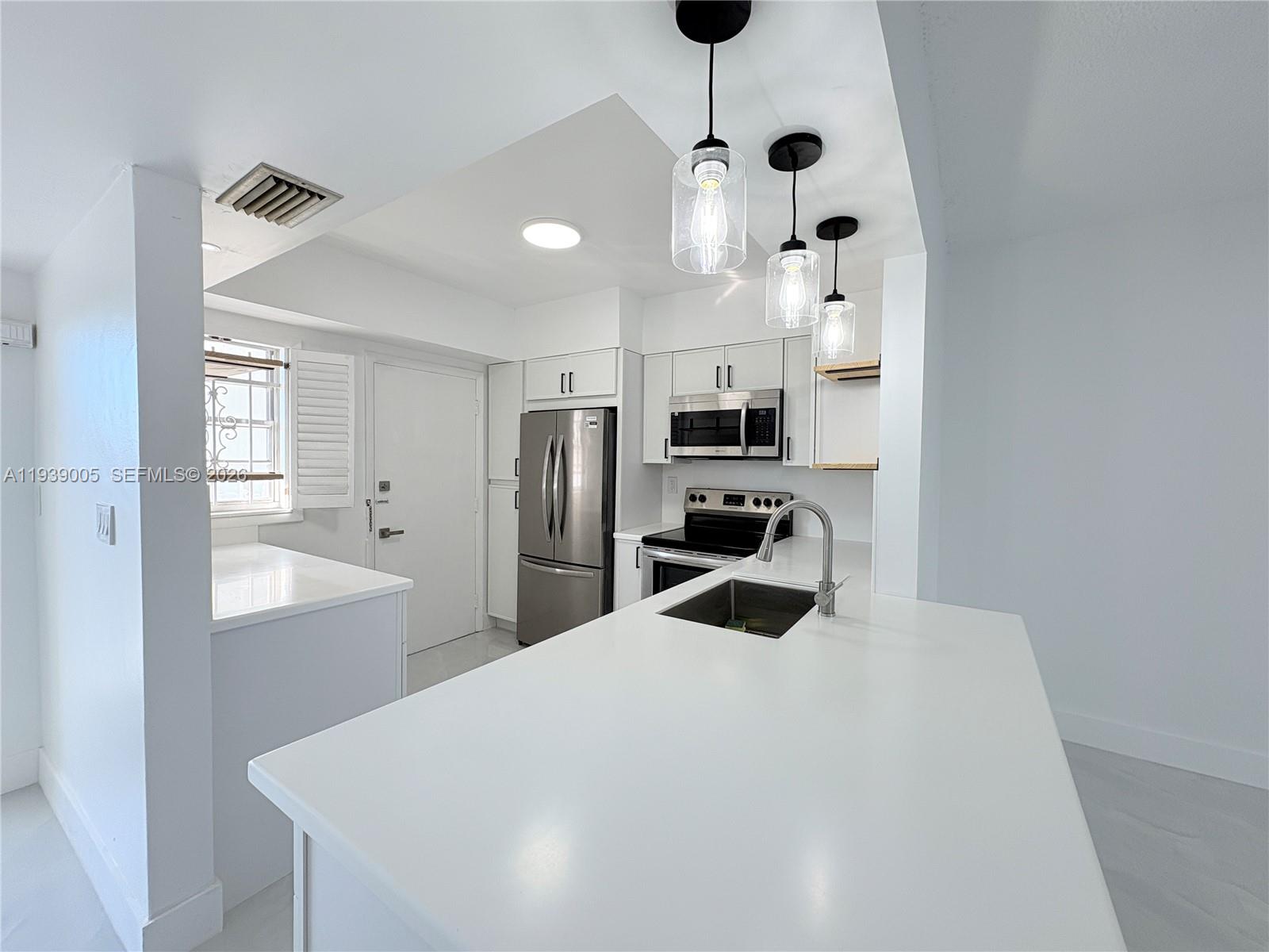 9159 Southwest 77th Avenue, Unit 314 Miami, FL 33156 - Photo 15 of 53 a kitchen with stainless steel appliances a refrigerator sink and microwave