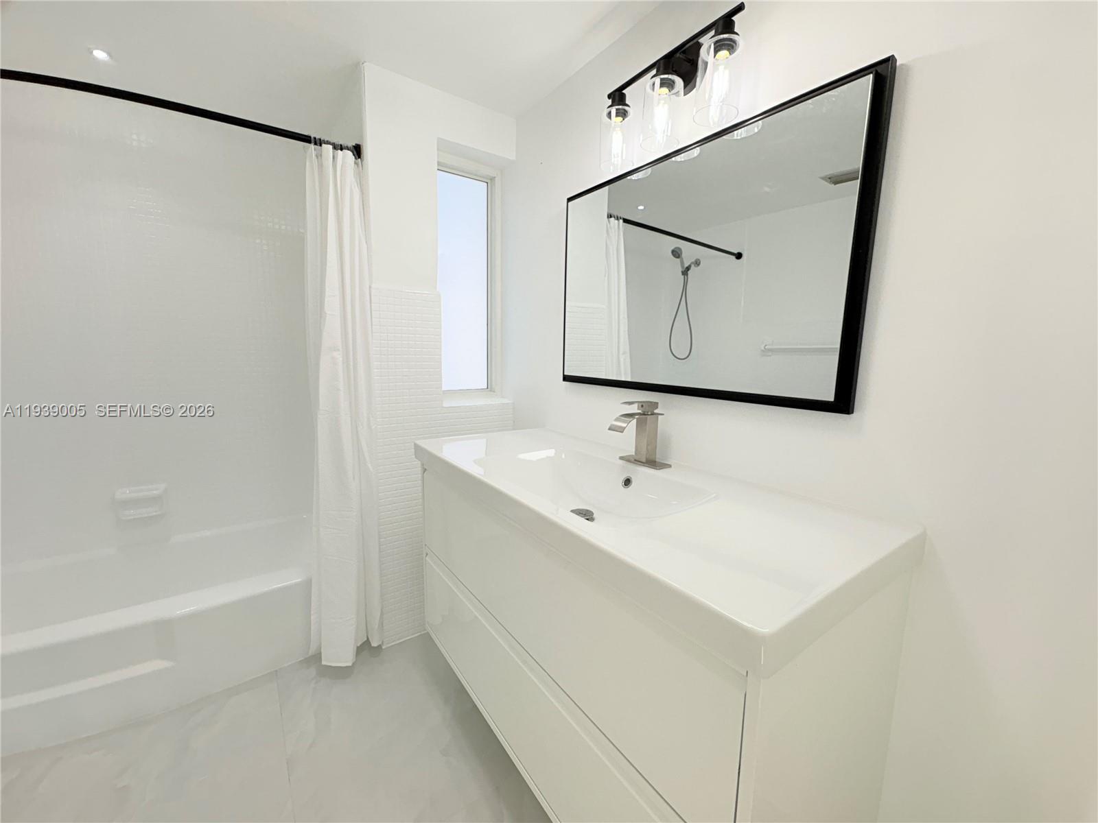 9159 Southwest 77th Avenue, Unit 314 Miami, FL 33156 - Photo 35 of 53 a bathroom with a bathtub a mirror a sink and vanity