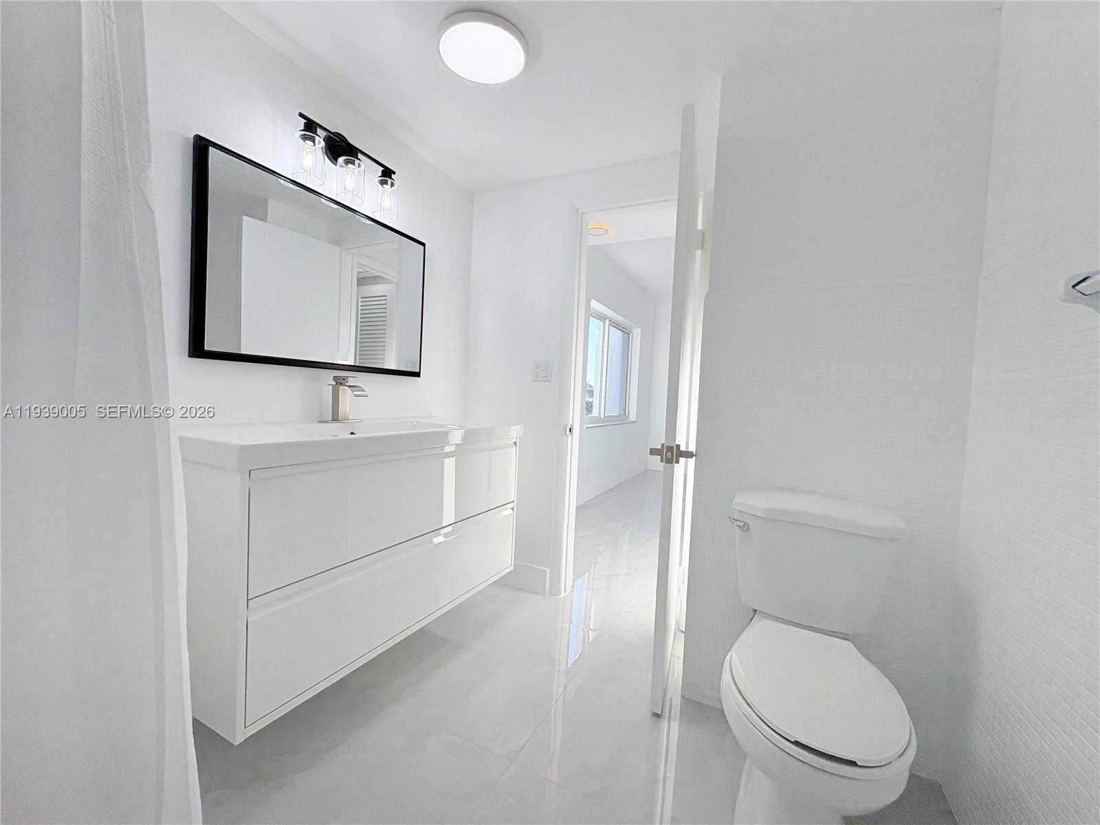 9159 Southwest 77th Avenue, Unit 314 Miami, FL 33156 - Photo 36 of 53 a bathroom with a toilet sink and mirror