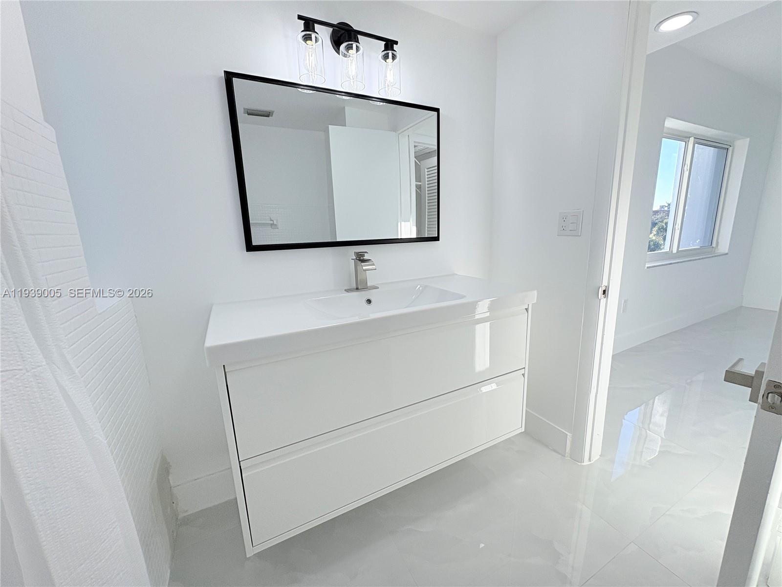 9159 Southwest 77th Avenue, Unit 314 Miami, FL 33156 - Photo 37 of 53 a bathroom with a sink vanity and mirror