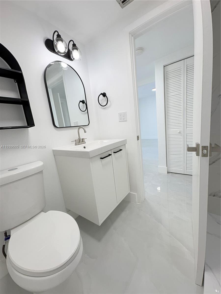 9159 Southwest 77th Avenue, Unit 314 Miami, FL 33156 - Photo 43 of 53 a bathroom with a toilet sink and mirror