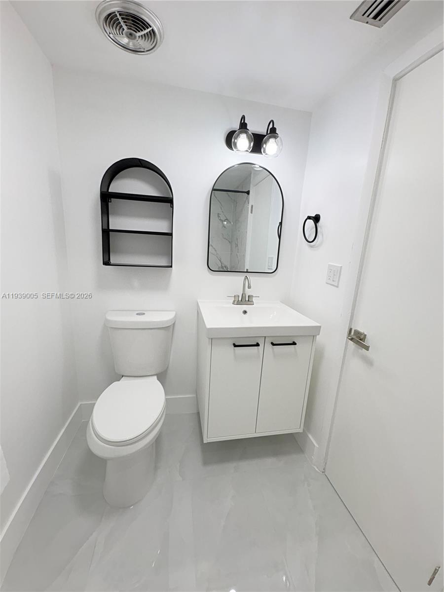 9159 Southwest 77th Avenue, Unit 314 Miami, FL 33156 - Photo 44 of 53 a bathroom with a toilet sink and mirror