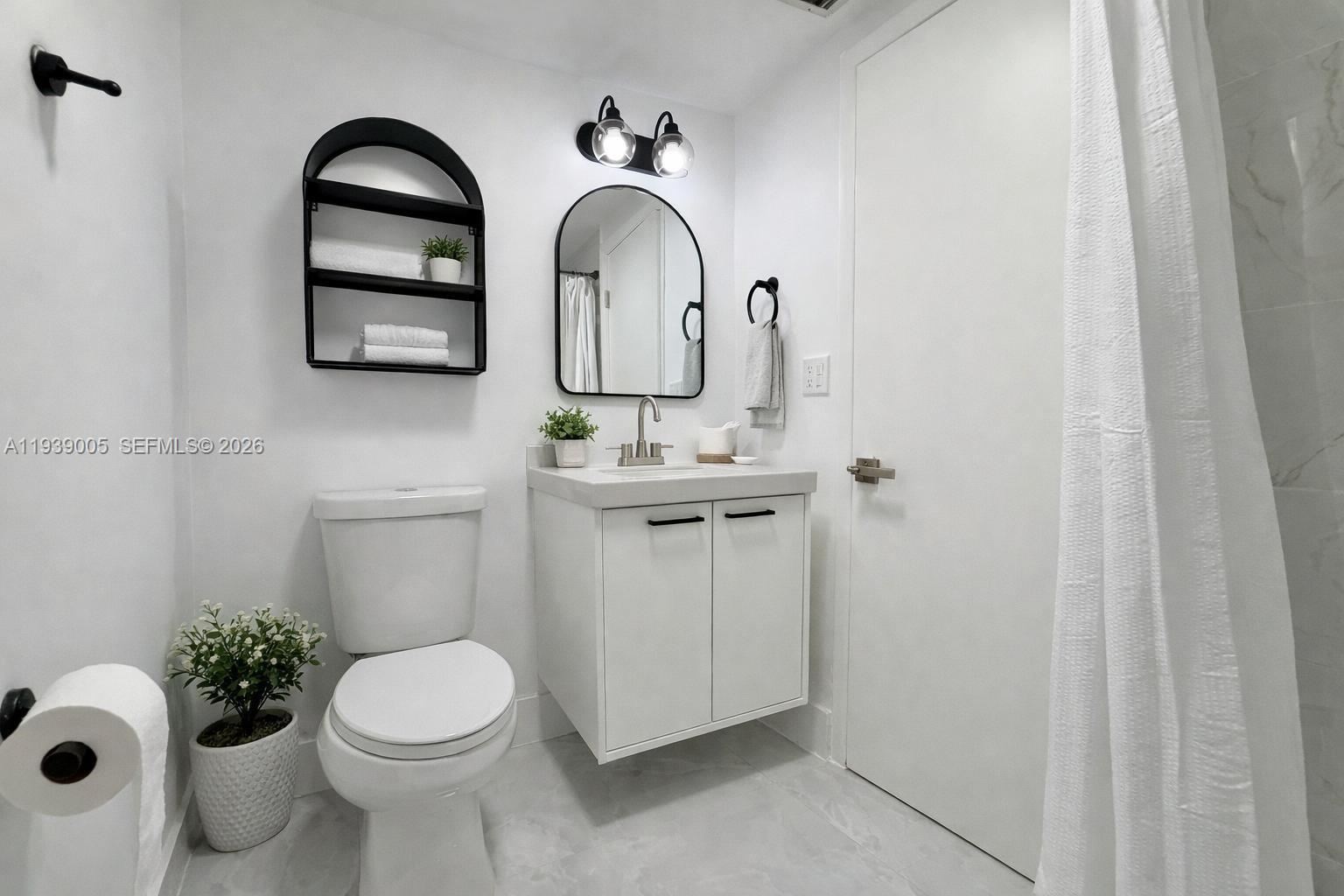 9159 Southwest 77th Avenue, Unit 314 Miami, FL 33156 - Photo 8 of 53 a bathroom with a toilet sink and mirror