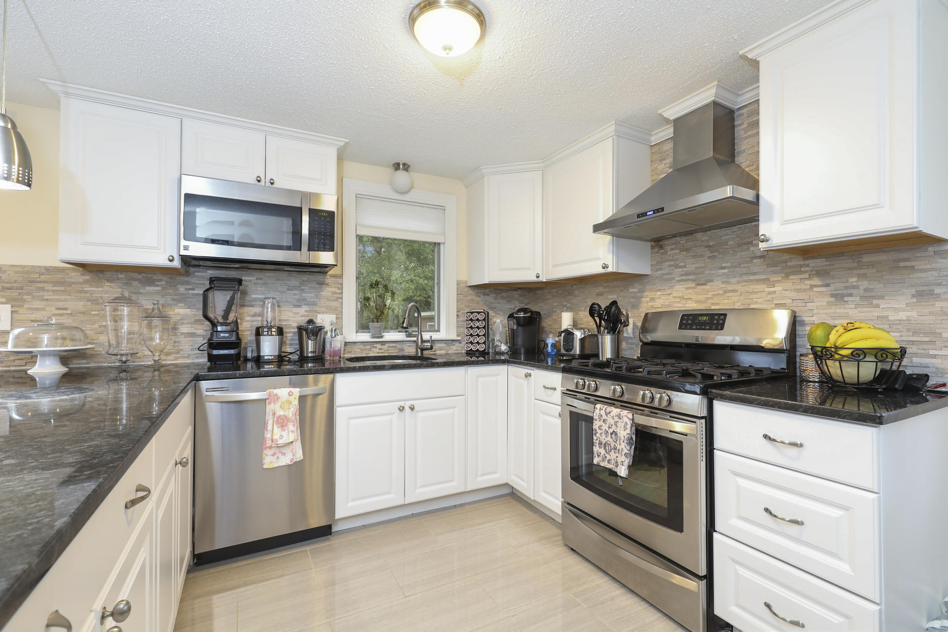 236 Megan Road Hyannis, MA 02601 - Photo 8 of 20 a kitchen with stainless steel appliances granite countertop a sink a stove and a microwave