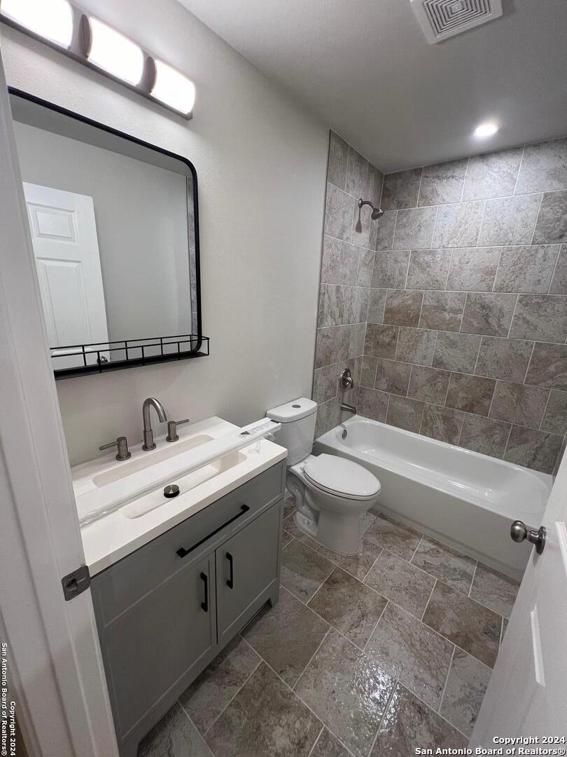1912 14th Street, Unit 8 Hondo, TX 78861 - Photo 4 of 7 a bathroom with a double vanity sink toilet mirror and bathtub