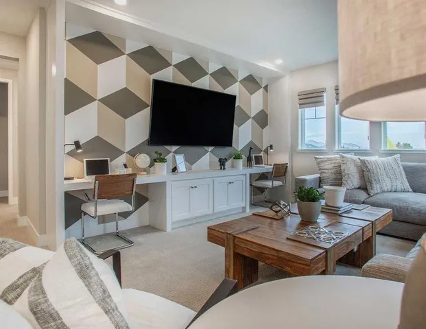 a living room with furniture a flat screen tv and kitchen view