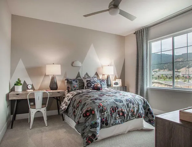 a bedroom with a bed a large window and potted plant on the dresser