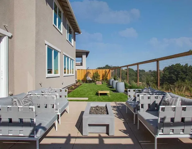a view of an house with backyard space and balcony