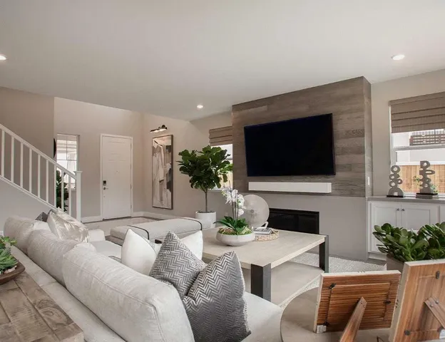 a living room with furniture a flat screen tv and a potted plant