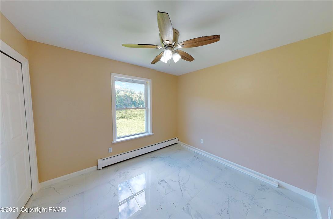 1110 Misty Ridge East Stroudsburg, PA 18302 - Photo 30 of 43 A well-lit bedroom with pristine tile flooring and a ceiling fan for comfort.
