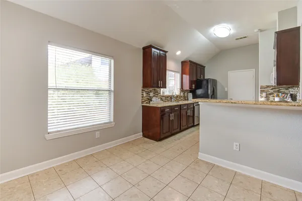 a kitchen with stainless steel appliances a sink a stove a refrigerator and cabinets