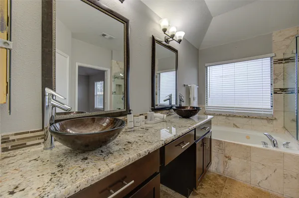 a bathroom with a granite countertop sink a toilet and bathtub