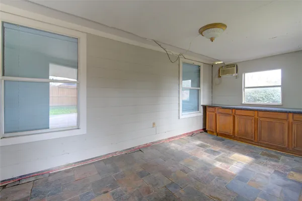 an empty room with windows and cabinet