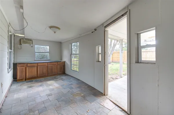 a view of an empty room with window and cabinet