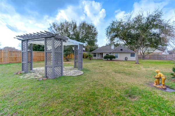 a view of a house with backyard and a tree