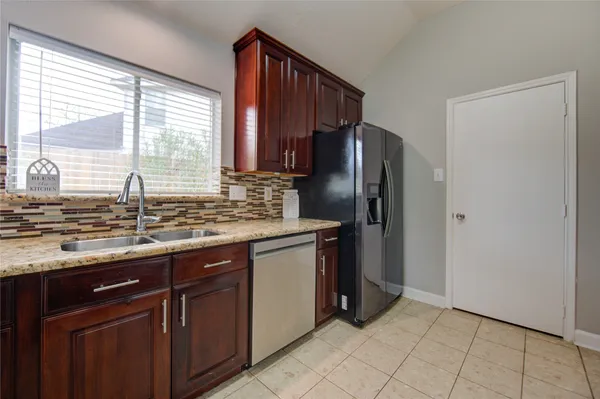 a kitchen with stainless steel appliances granite countertop a refrigerator and a sink