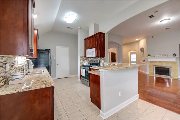 a large kitchen with stainless steel appliances kitchen island granite countertop a stove and a sink