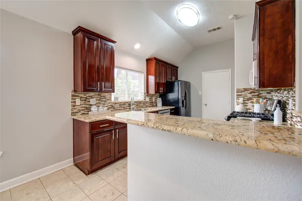 a kitchen with stainless steel appliances granite countertop a sink stove and cabinets