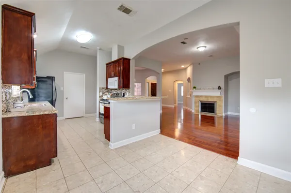 a kitchen with stainless steel appliances kitchen island granite countertop a refrigerator and a stove top oven