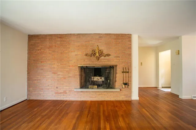 a view of a livingroom with wooden floor and a fireplace