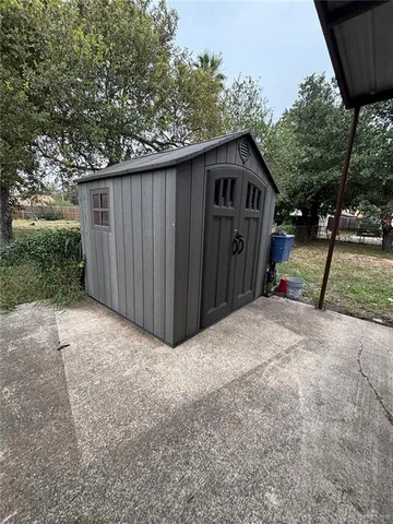 a view of wooden house with a yard and large trees