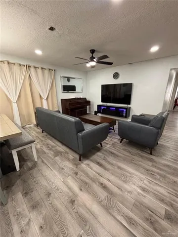 a living room with furniture a flat screen tv and a window