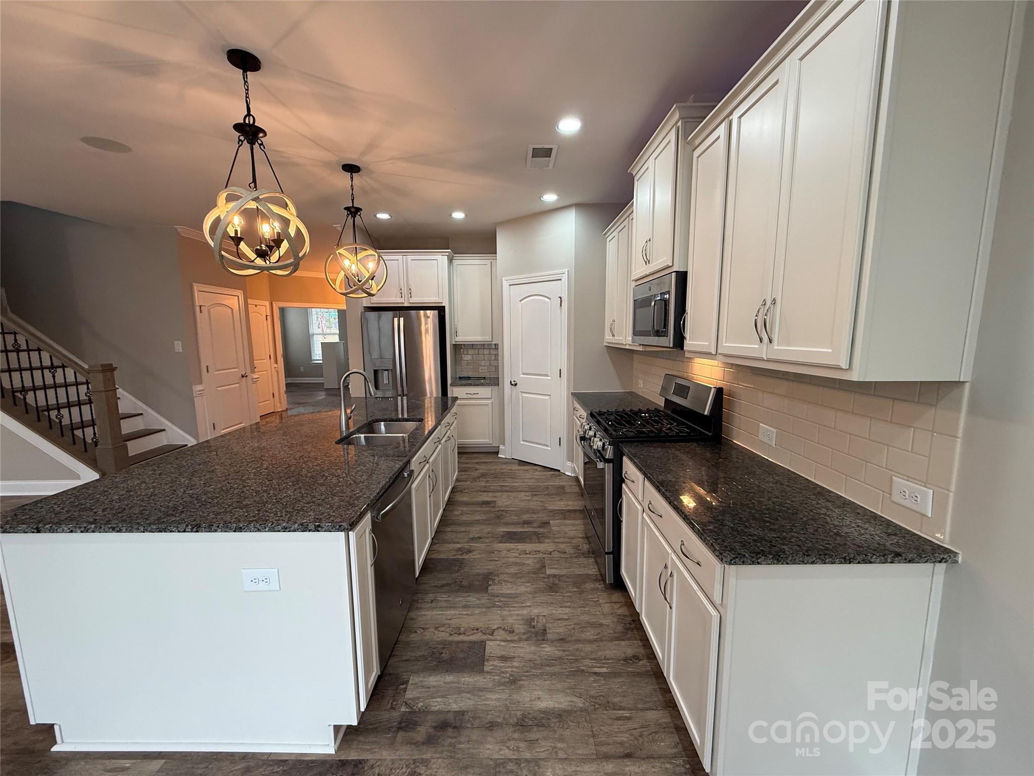 1073 Moonlight Mist Road Belmont, NC 28012 - Photo 3 of 20 a kitchen with stainless steel appliances granite countertop a sink a stove and a wooden floors
