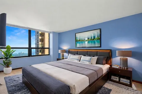 a bedroom with a large bed and a potted plant