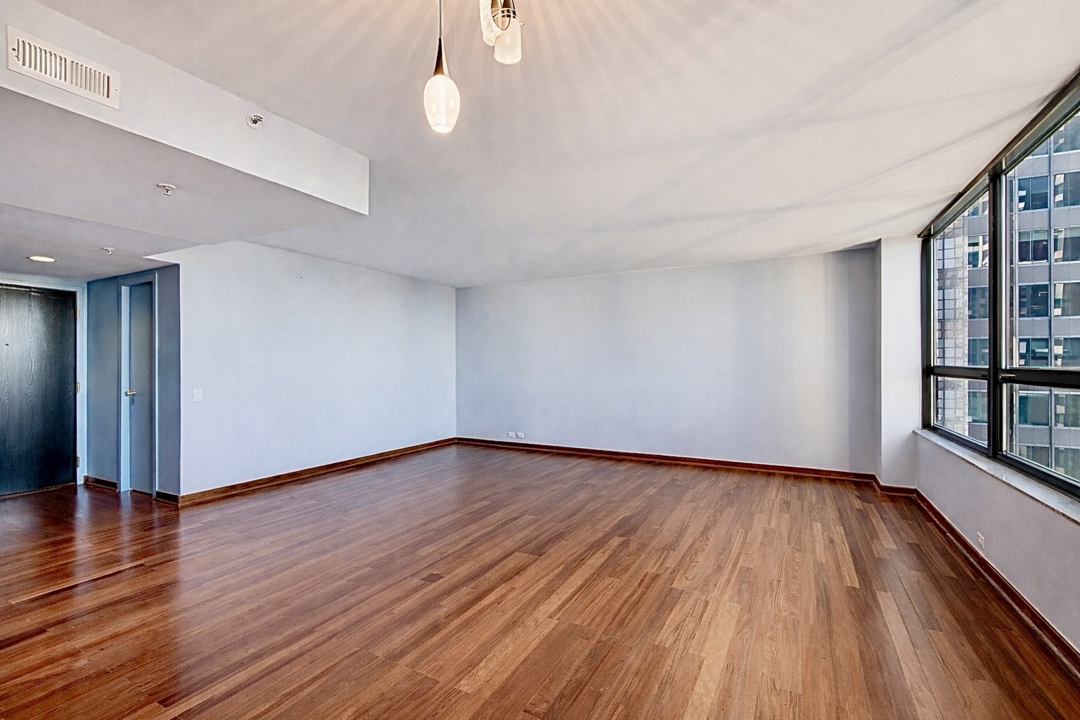 400 East Ohio Street, Unit 2902 Chicago, IL 60611 - Photo 5 of 34 a view of an empty room with wooden floor and a window