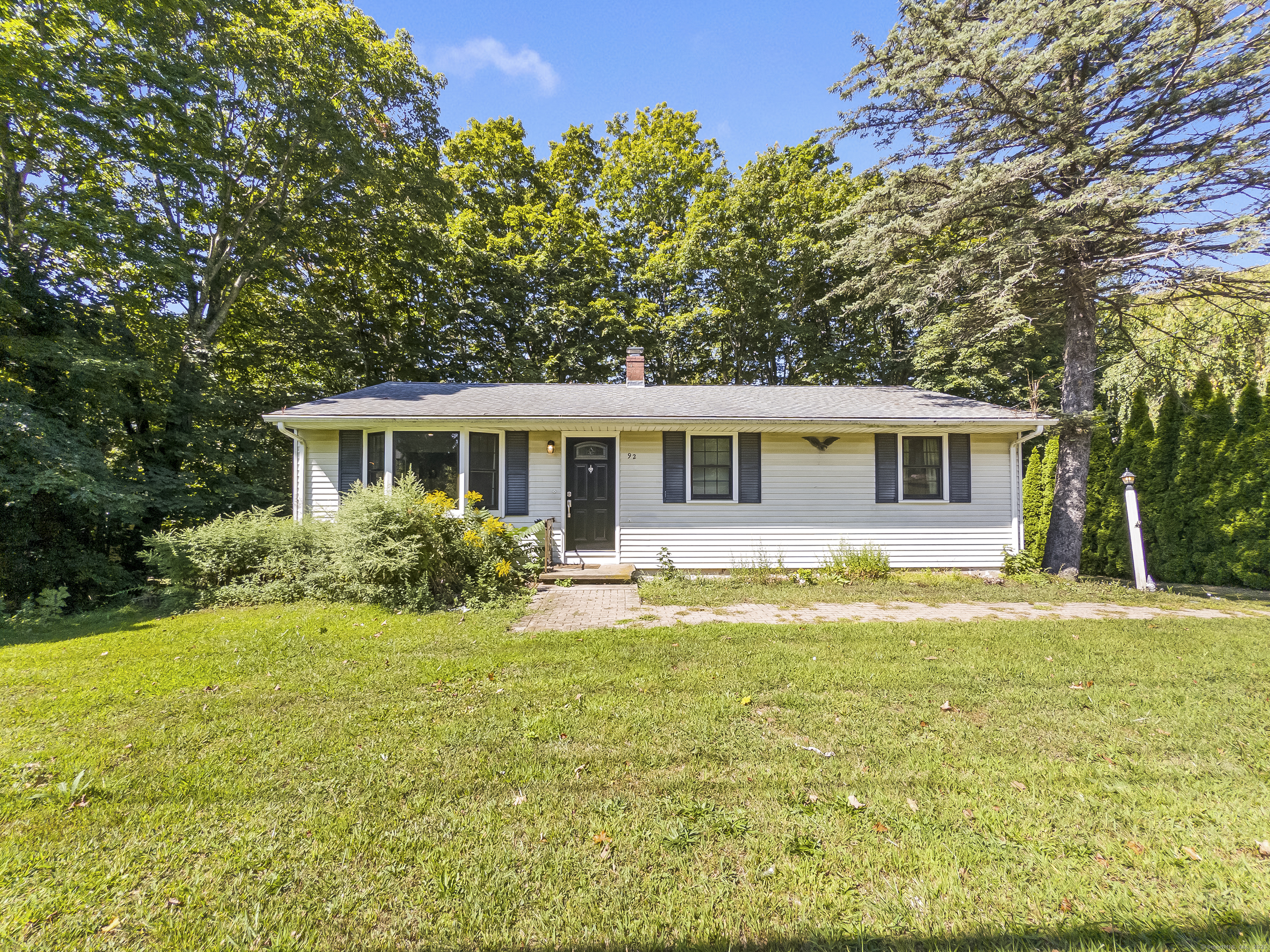 a view of a house with a yard and a tree